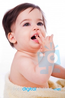 Baby With Finger In Mouth Looking Up Stock Photo