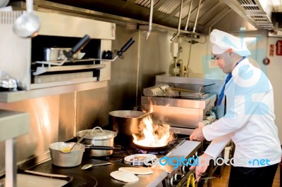 Chef Preparing  Cuisine In Hotel Kitchen Stock Photo