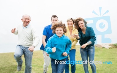 Happy Family Running On A Green Meadow Stock Photo
