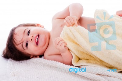 Little Smiling Baby Lying In White Towel And Wrapped With Yellow Towel Stock Photo
