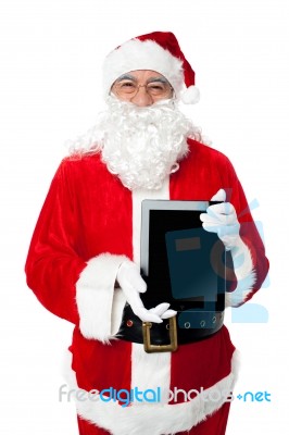 Old Man In Santa Costume Posing With A Tablet Pc Stock Photo
