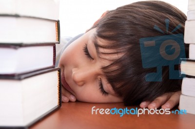 School Boy Tired Of Studying And Sleeping With Books Stock Photo