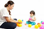 Baby Girl Is Playing Ball With Her Mother On White Background Stock Photo