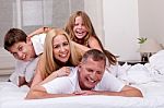 Family Having Fun In Bed Stock Photo