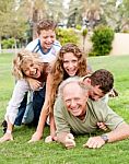 Family Piling Up On Dad Stock Photo
