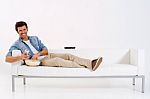 Man On Sofa Watching TV With Remote Stock Photo