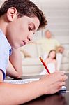 Young Boy Writing In Notebook Stock Photo