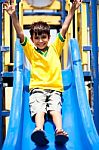 Young Smart Kid Sliding Down The Swing Stock Photo