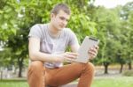 Young Man With Tablet Computer Joy In Park Stock Photo