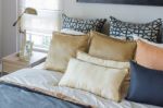 Pillows On Luxury Bed With White Lamp In Bedroom Stock Photo