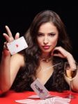 Woman Throwing Gambling Cards On Red Table Stock Photo