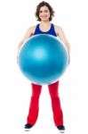 Female Instructor Displaying Pilates Ball Used In Gym Stock Photo