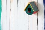 Colorful Bird House On Grunge Wall Stock Photo