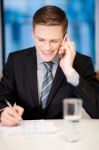 Smiling Corporate Guy Attending Phone Call Stock Photo