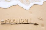 Inscription Of Vacation Written On Wet Yellow Beach Sand With Fo Stock Photo