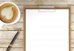 Cappuccino Coffee Cup With Blank Papers On Clipboard And Ballpoint Pen On Wooden Background, Coffee And Business Background Stock Photo