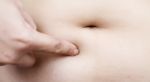 Female Hand Touching Stomach Fat Stock Photo