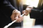 Hand Pulling The Rope, Grey Background, Cooperation Concept As A Stock Photo