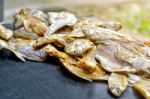 Dry Fish With Sunny On Black Wooden Floor Stock Photo