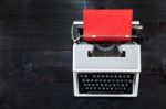 Typewriter And A Red Paper  On Wooden Background Retro Stock Photo