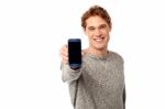 Young Man Displaying Brand New Cellphone Stock Photo