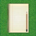 Notebook With White Page On Green Grass Background Stock Photo