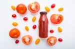 Tomatoes Juice In Bottle And Fresh Tomatoes Slices On White Wood Stock Photo