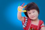 Adorable Little Asian (thai) Girl Painting Her Palm, On Blue Bac Stock Photo