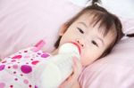 Beautiful Little Asian Girl Lying And Suck Up Milk Stock Photo