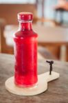 Red Syrup In The Bottle On Wooden Plate Stock Photo