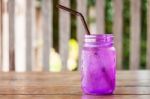 Iced Drink In Violet Glass In Coffee Shop Stock Photo