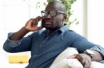 Handsome Young Man Using His Mobile Phone At Home Stock Photo