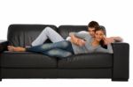 Teenage Couple Lying On Sofa Stock Photo