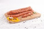 Wooden Chopping Board With Sausages And Spices Stock Photo