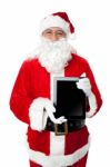 Old Man In Santa Costume Posing With A Tablet Pc Stock Photo