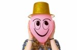 Girl Holding Balloon With Smiling Face And Hat Stock Photo