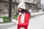 Beautiful Woman In Red Coat And Wool Cap And Gloves With Smartph Stock Photo