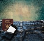 Blue Jeans With Cell Phone And Passport In A Pocket Background Stock Photo