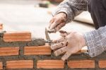 Bricklayer Working In Construction Site Of A Brick Wall Stock Photo