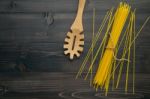 The Thin Spaghetti On Black Wooden Background. Yellow Italian Pa Stock Photo