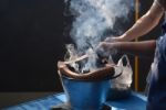 Two Hands Helped Kindled A Fire In Charcoal Stove And Smoke Stock Photo