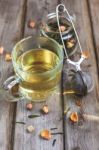 Mug Of Flavored Green Tea With Rose Buds And Petals Stock Photo