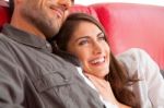 Smiling Woman With Boyfriend Relaxing On Sofa Stock Photo