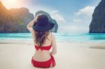 Young Woman In Red Bikini Sitting On The Beach Stock Photo