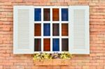 Beautiful White Wooden Window With Colorful Flowers On Old Brick Wall Stock Photo