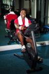 Guy Working Out In Exercise Bike Stock Photo