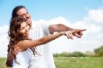 Hugging Couple Pointing Out Stock Photo