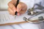 Hand Of Doctor Writing On Prescription Stock Photo