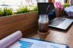 Coffee Cup  On A Table With Laptob And Graph Finance Diagram In Stock Photo