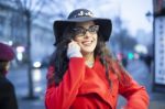 Woman In Red Coat With Smartphone In Hands Going Through The Cit Stock Photo